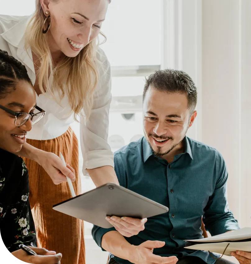 A group of coworkers view an tablet device in an office setting