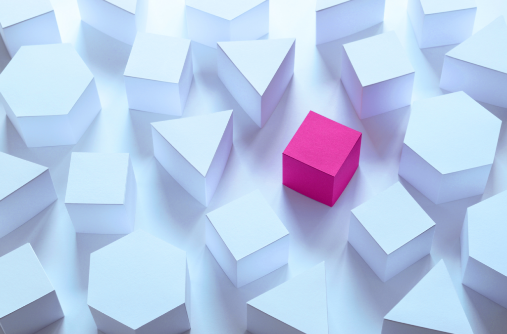 several three dimensional white shapes sit amongst a long magenta cube