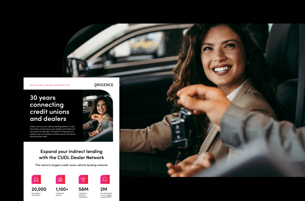 A woman sits in a car inside a dealership while she is handed a set of keys