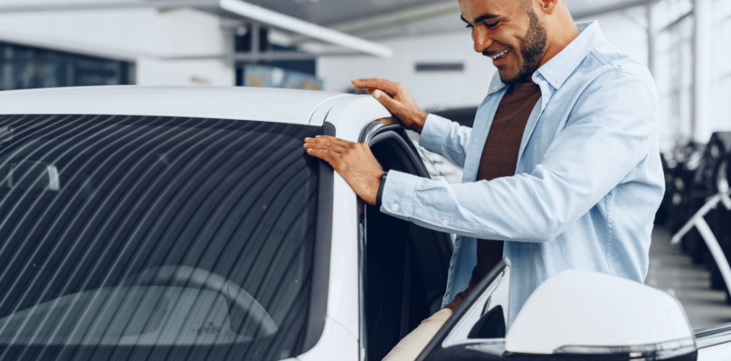 A prospective car buyer checking out a new car representing indirect lending success.