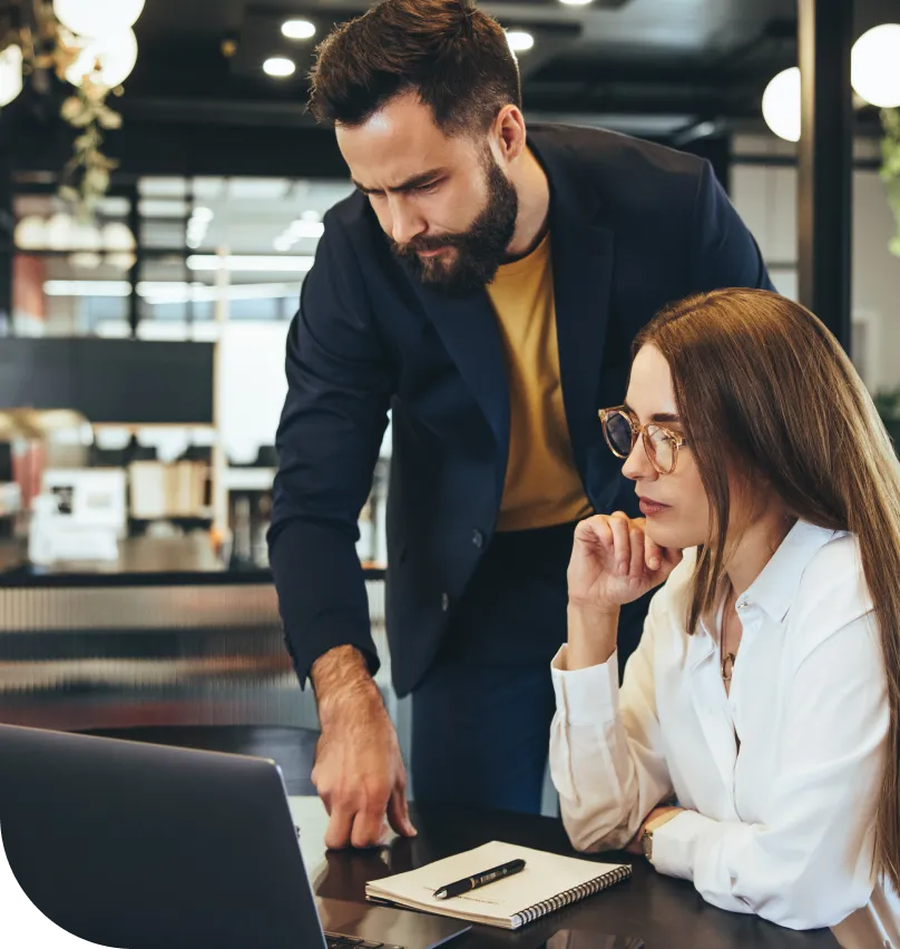 A male and female employee using a laptop in office