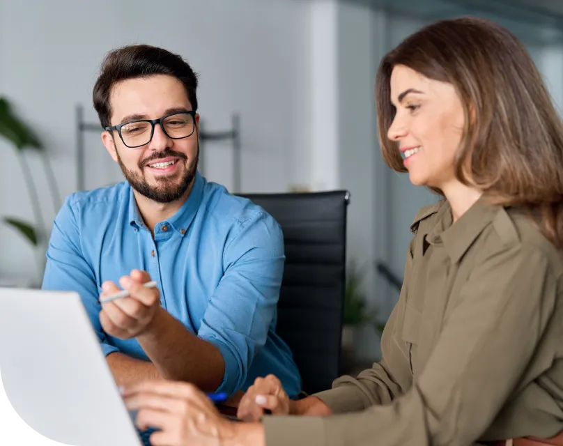 A man and woman collaborate using a laptop computer