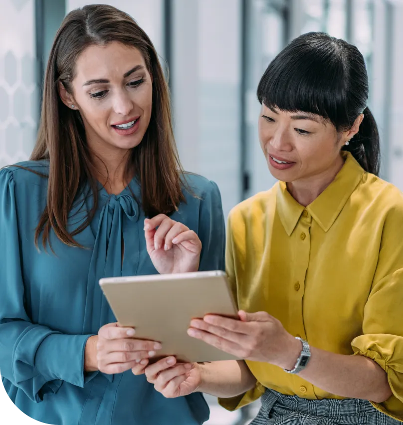 two women view a tablet computer