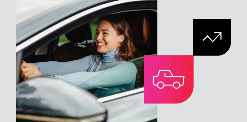 A smiling woman drives a car