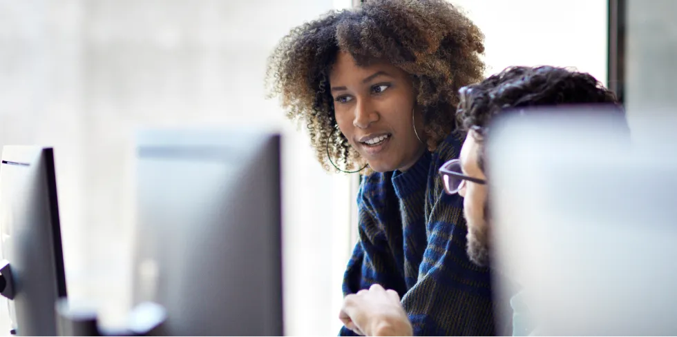 Two credit union employees work together in an office