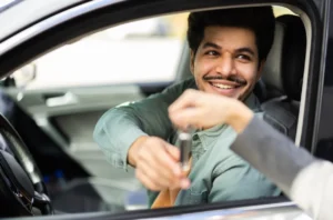 Customer receiving the keys for his new vehicle. He utilized credit union auto lending as it pertains to financing.