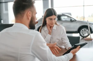 A customer reviewing their financing application with the finance manager representative indirect auto lending transformation.
