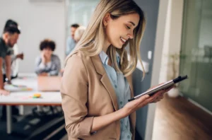 A credit union leader viewing the outsourcing performance metrics and how they measure up against the current lending environment on her tablet.