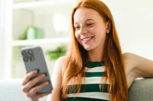 A credit union member viewing their digital application on the mobile device representing growth a credit union loan portfolio.