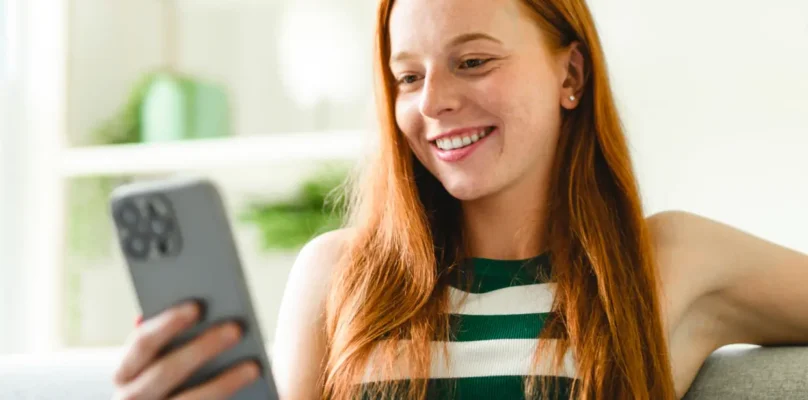 A credit union member viewing their digital application on the mobile device representing growth a credit union loan portfolio.